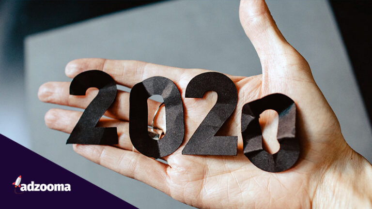 The year 2020 spelt out in cut out paper and held in a hand